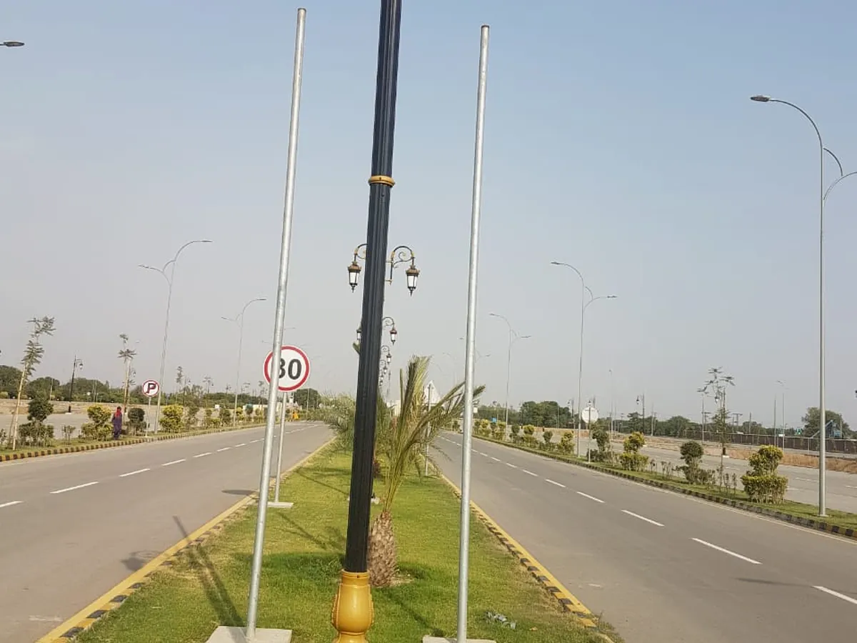 Street light poles installed along a wide road